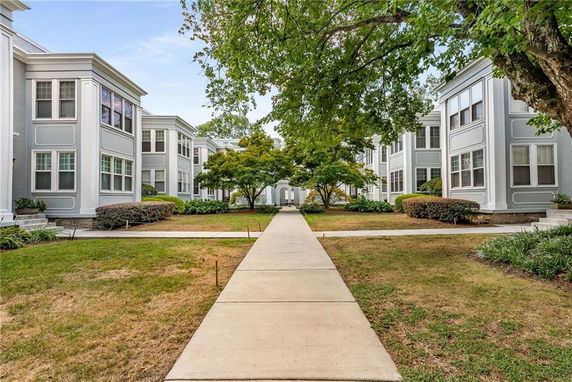 Front view of two-story residential buildings with a central pathway and greenery.