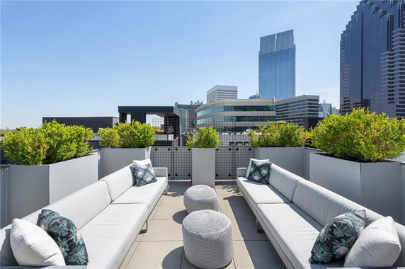Rooftop seating area with modern sofas and cityscape view.