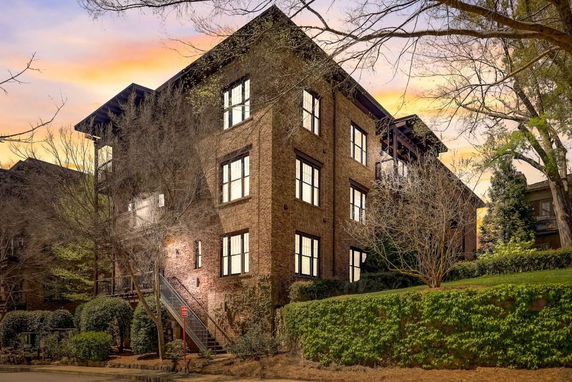 Front view of a multi-story brick building with large windows.