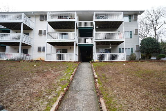 Front view of a multi-story apartment building with multiple balconies.