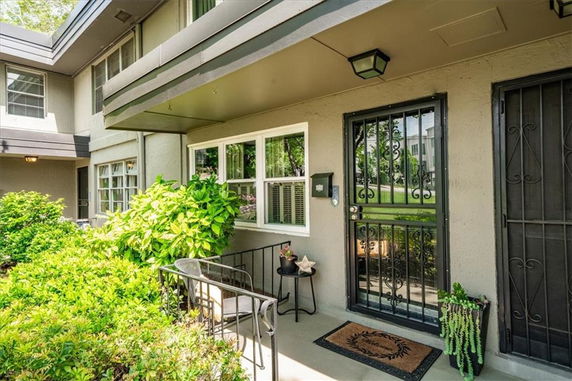 Front view of a two-story building with a small patio area and metal security doors.