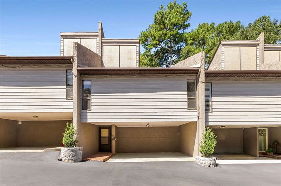 Front view of a multi-story house with a modern design and covered parking.