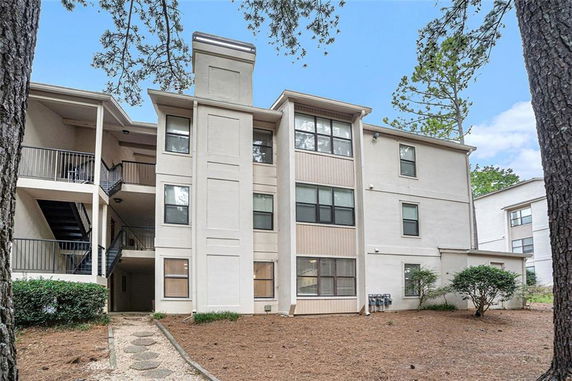 Front view of a multi-story apartment building with exterior staircases.