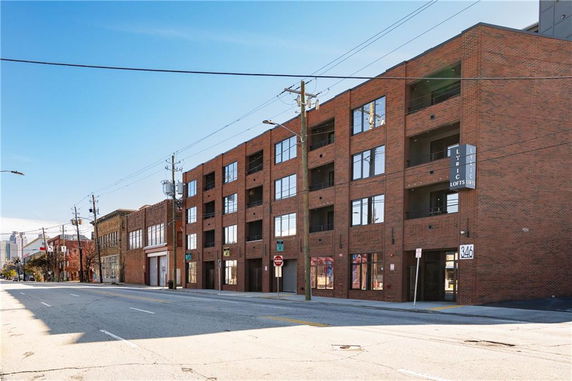 Front view of a multi-story brick building along a street.