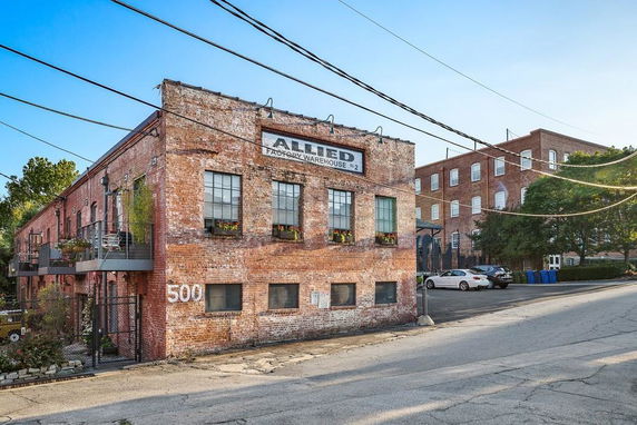 Front view of a brick warehouse building with multiple windows.