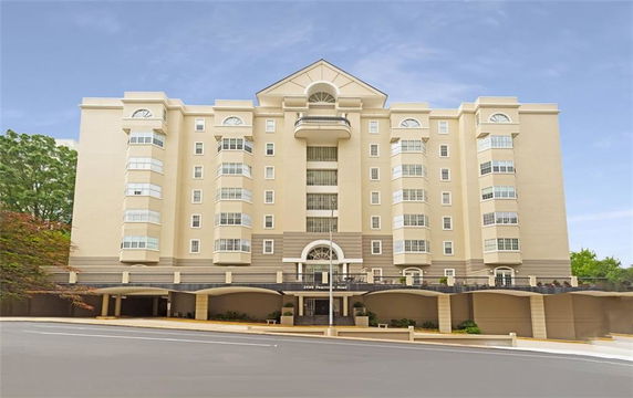 Front view of a multi-story building with covered parking.