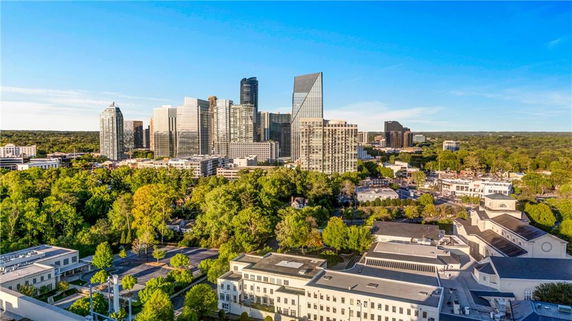 Aerial view of a city with modern skyscrapers and greenery.