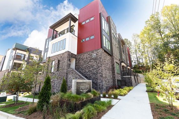 Front view of a modern multi-story residential building with a mix of brick and panel facade.