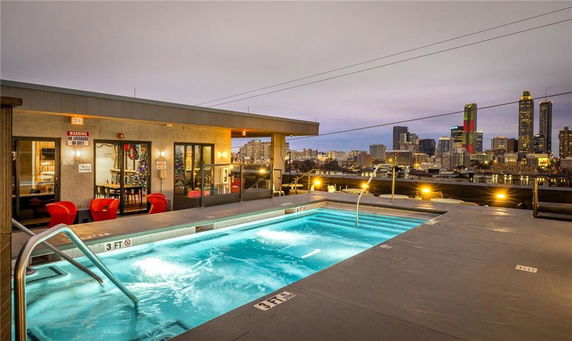 Rooftop swimming pool area with a view of the city skyline.
