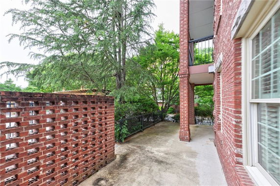 Side view of a building with red brick walls and a partially enclosed outdoor area.