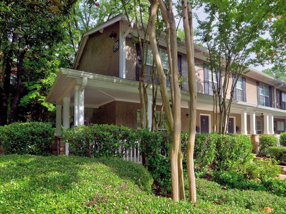 Front view of a two-story building with a porch and multiple windows.