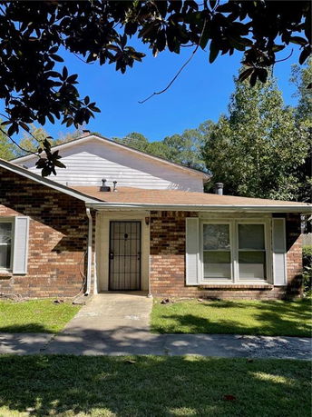 Front view of a two-story brick house with white shutters.