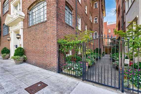 Front view of a brick building with an arched metal gate entrance.