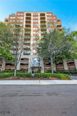 Front view of a multi-story apartment building with balconies.