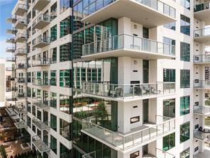 Corner view of a modern multi-story apartment building with glass balconies.
