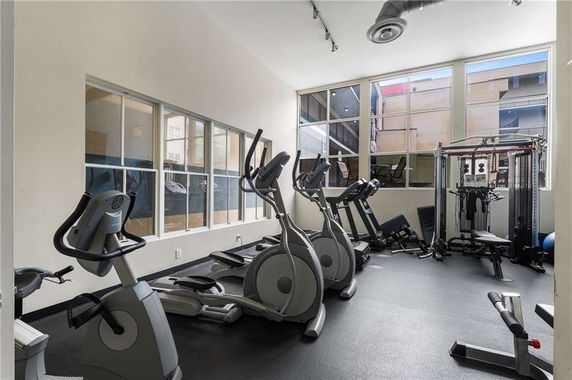Indoor gym area with exercise equipment and large windows.