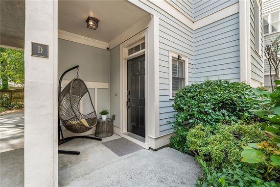 Front view of a house with a covered entrance and a hanging chair.