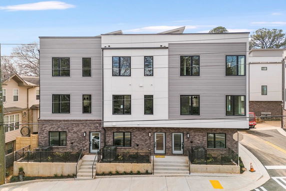 Front view of a modern three-story building with a combination of brick and siding exterior.