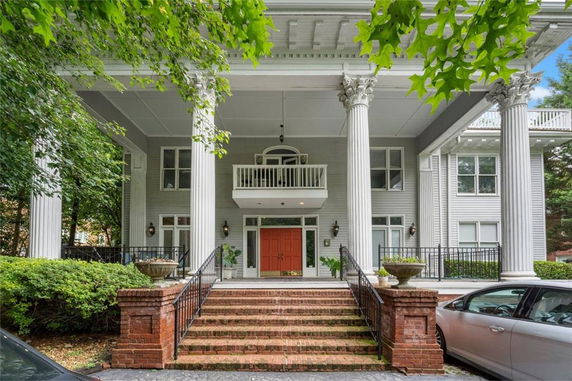 Front view of a two-story house with large pillars and a central entrance.