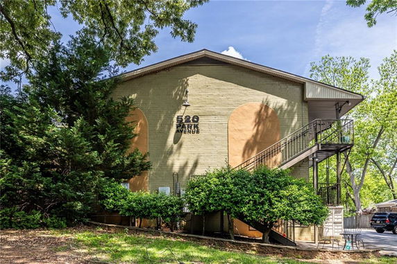 Front view of a two-story building with a staircase and a small patio area.