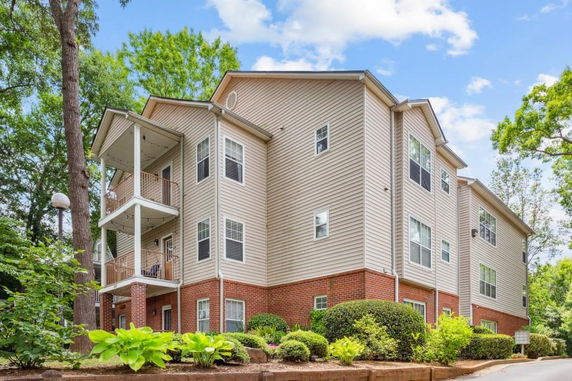 Front view of a multi-story residential building with brick and siding exterior.