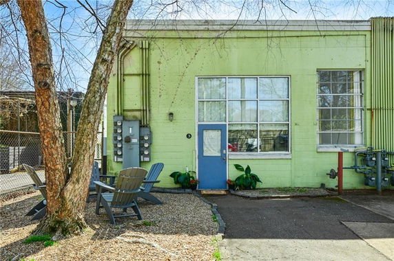 Front view of a small, single-story building with a blue door and large windows.