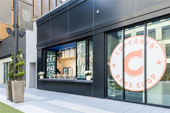 Front view of a modern commercial bake shop with large signage.