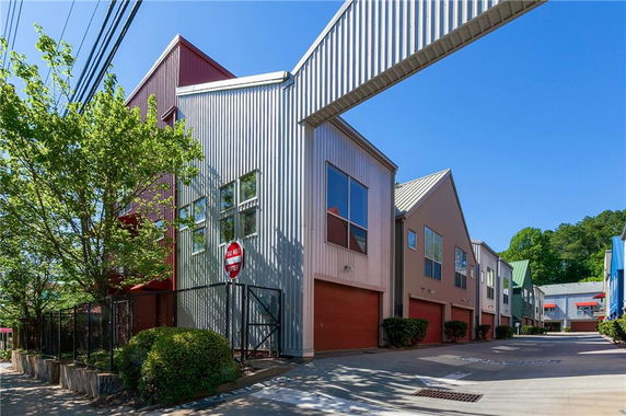 Front view of a row of modern, metal-clad townhouses with distinct rooflines.