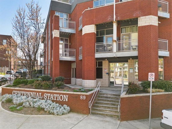 Front view of a multi-story building with brick exterior and balconies.