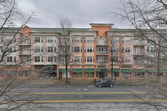Front view of a multi-story building with storefronts on the ground level.