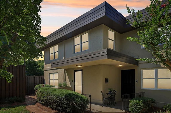 Front view of a two-story modern house with a flat roof and balcony area.