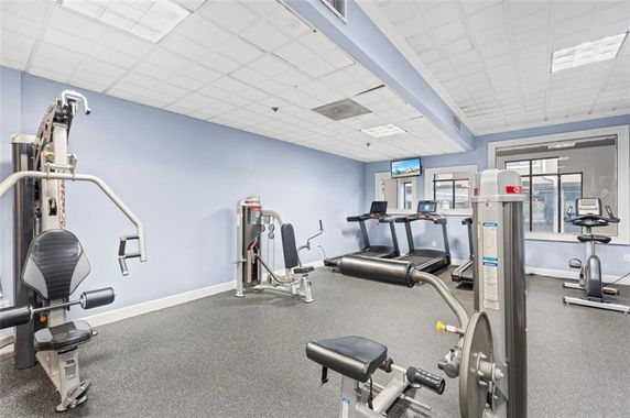 Indoor gym area with fitness machines including treadmills and weight equipment.