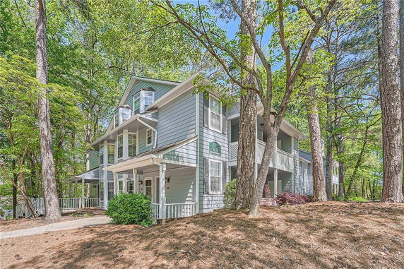 Front view of a two-story house with a wrap-around porch.