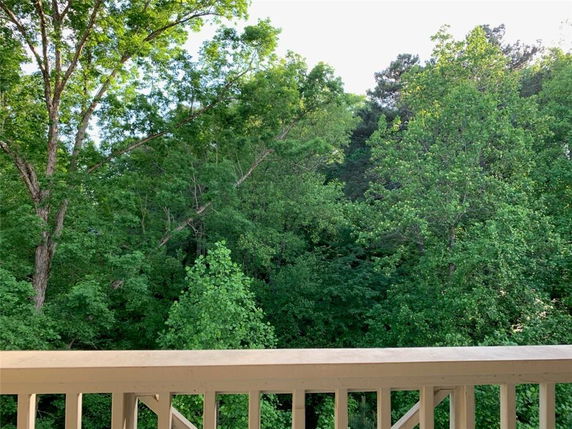 Panoramic view over forested area from a balcony.