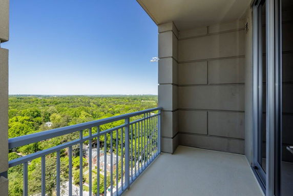 View from a balcony overlooking a vast green landscape.