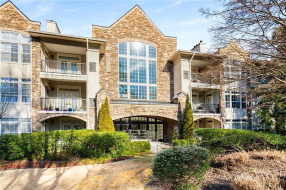 Front view of a multi-story building with stone facade and balconies.