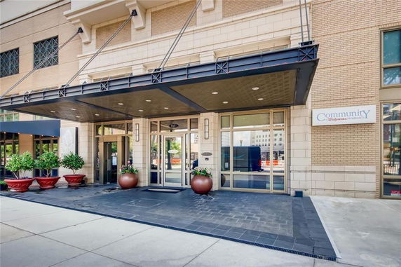 Front view of a building entrance with large glass doors and metal canopy.