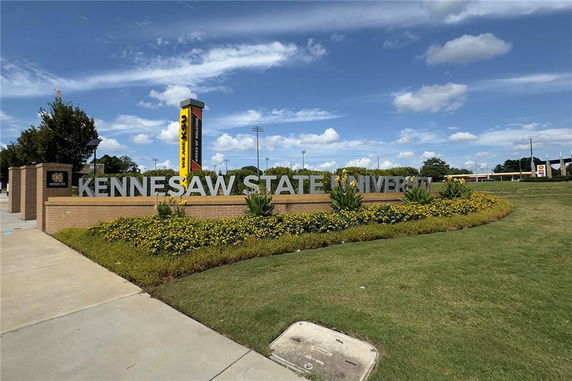 Front view of Kennesaw State University entrance sign against a clear blue sky.