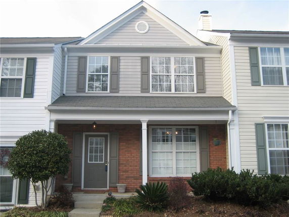Front view of a two-story house with brick and siding exterior.
