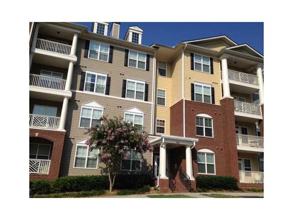 Front view of a multi-story apartment building with balconies and varied exterior colors.