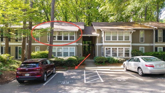 Front view of a two-story apartment building with parking spaces in front.