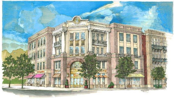 Front view of a multi-story commercial building with several windows and storefronts, featuring a central archway entrance.