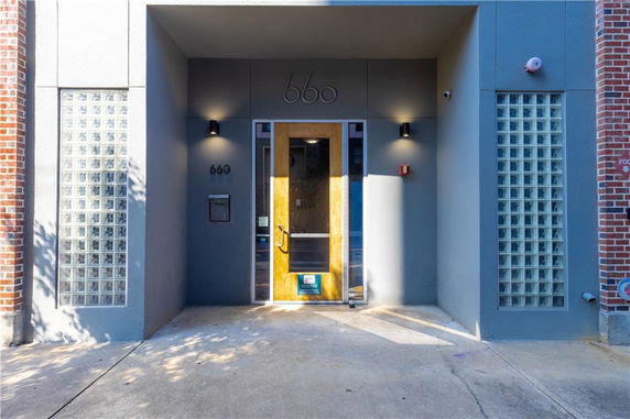 Front view of a building entrance with glass blocks and a wooden door.