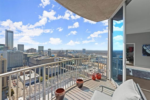 Panoramic cityscape view from a high-rise building balcony.