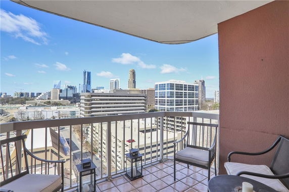 View of city skyline from a balcony with chairs.