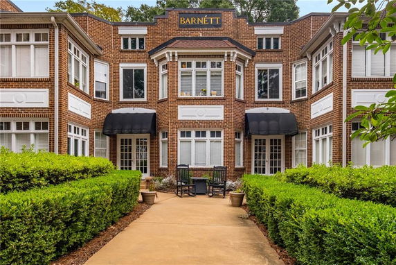 Front view of a two-story brick building with multiple windows and awnings.