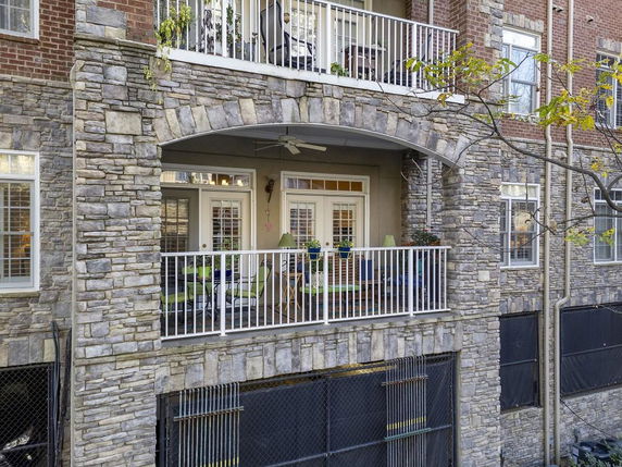 Front elevation of a multi-story building with stone facade and balconies.