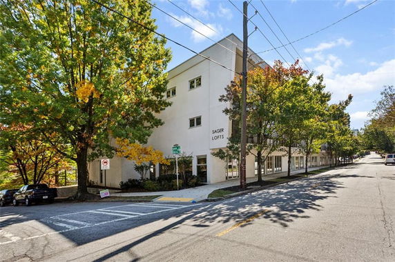 Front view of a multi-story building named Sager Lofts on a tree-lined street.