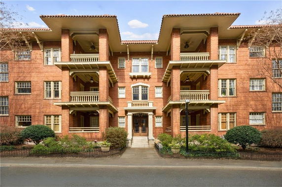 Front view of a multi-story brick building with balconies.