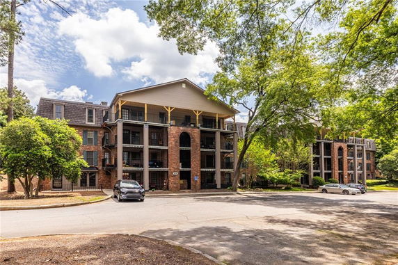 Front view of a multi-story apartment building with brick facade and balconies.